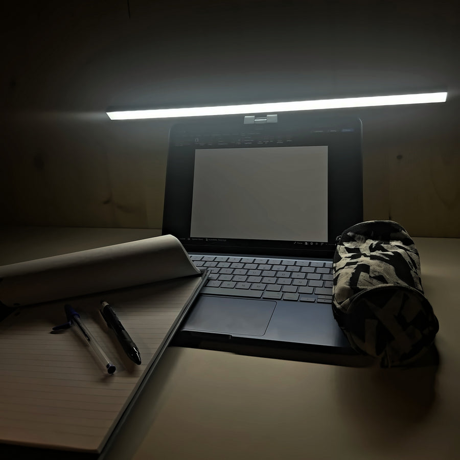 Estudiando de noche con la lámpara Cenit de 50 cm: apuntes, bolígrafos y la mesa iluminada