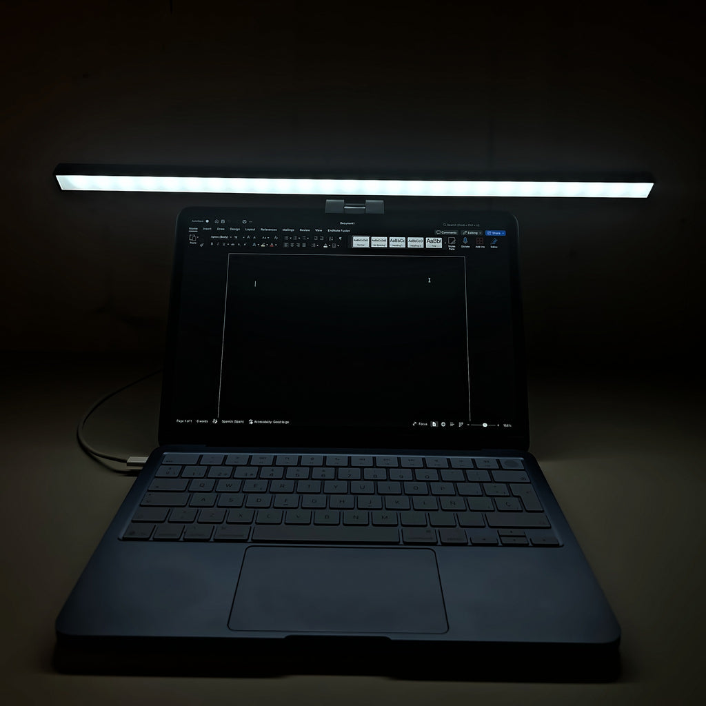 Lámpara Cenit de 50 cm con luz blanca sobre un portátil en una habitación a oscuras