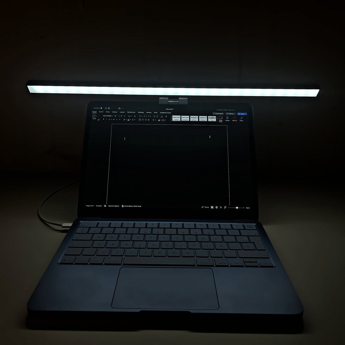 Lámpara Cenit de 50 cm con luz blanca sobre un portátil en una habitación a oscuras