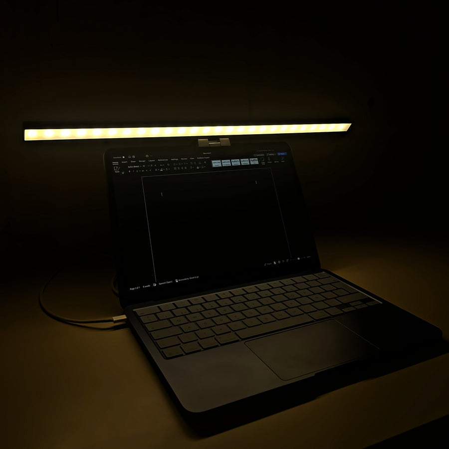 Lámpara Cenit de 50 cm con luz cálida sobre un portátil de noche