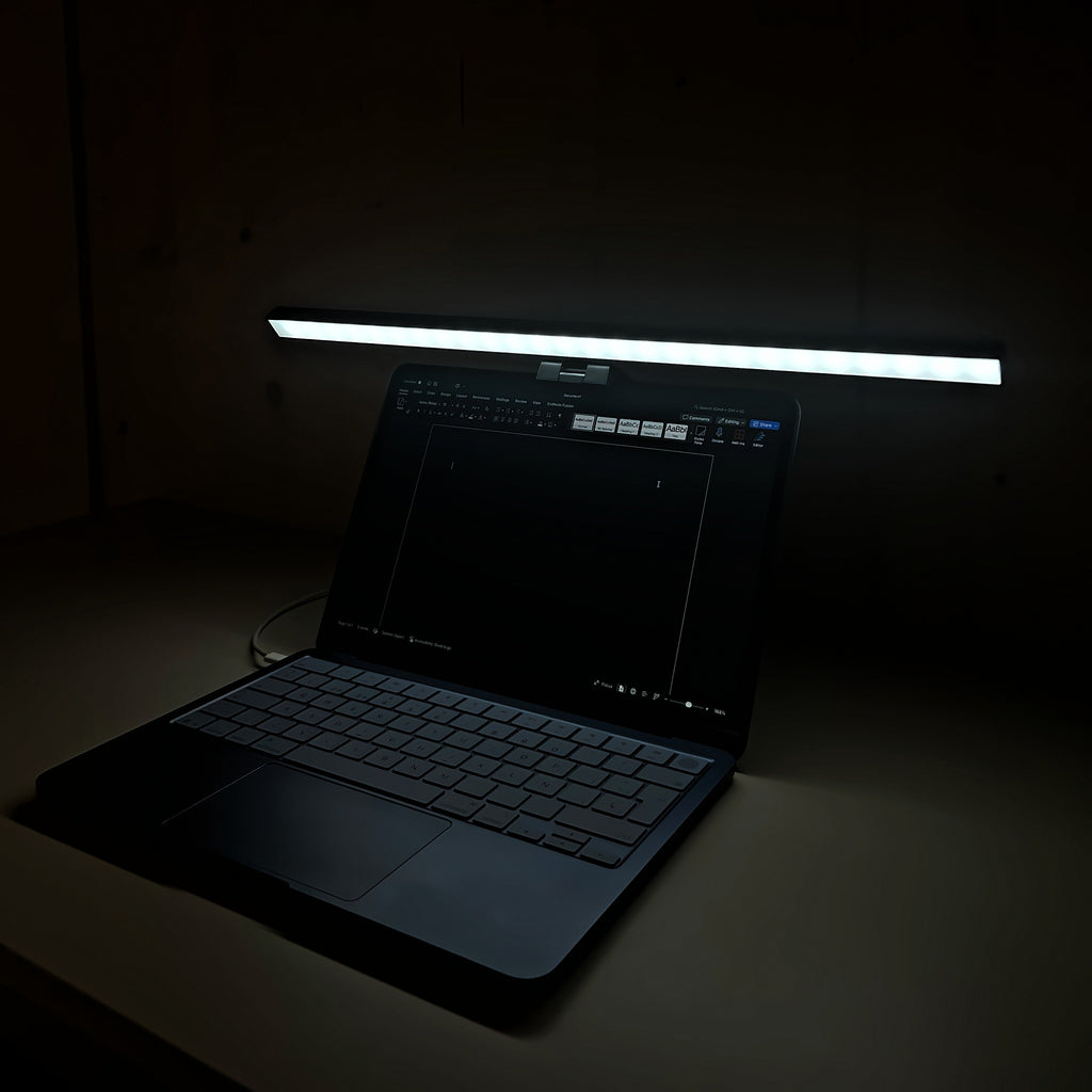 Lámpara Cenit de 50 cm con luz blanca iluminando el teclado del portátil de noche