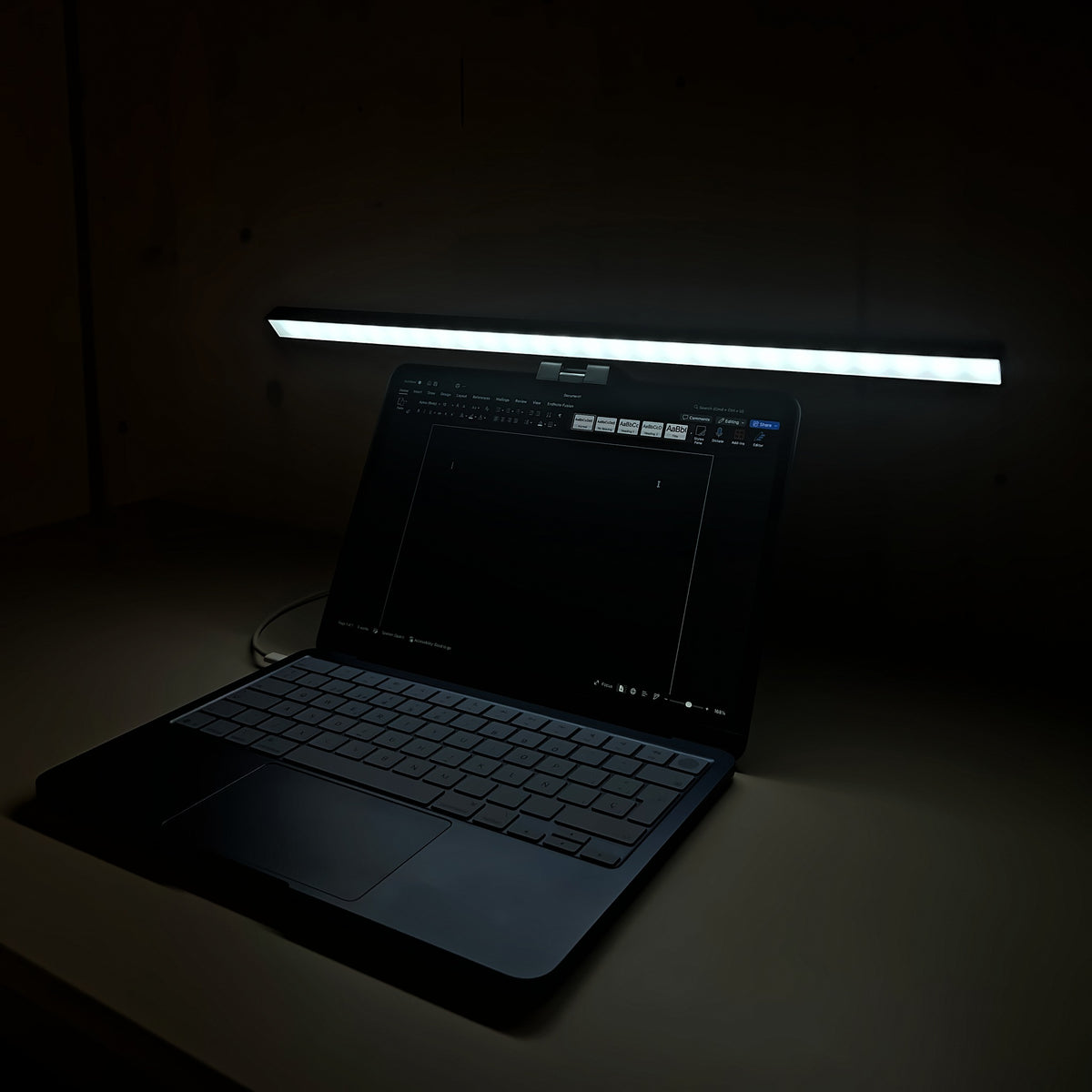 Lámpara Cenit de 50 cm con luz blanca iluminando el teclado del portátil de noche