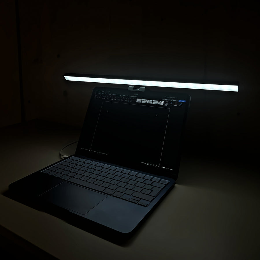 Lámpara Cenit de 50 cm con luz blanca iluminando el teclado del portátil de noche