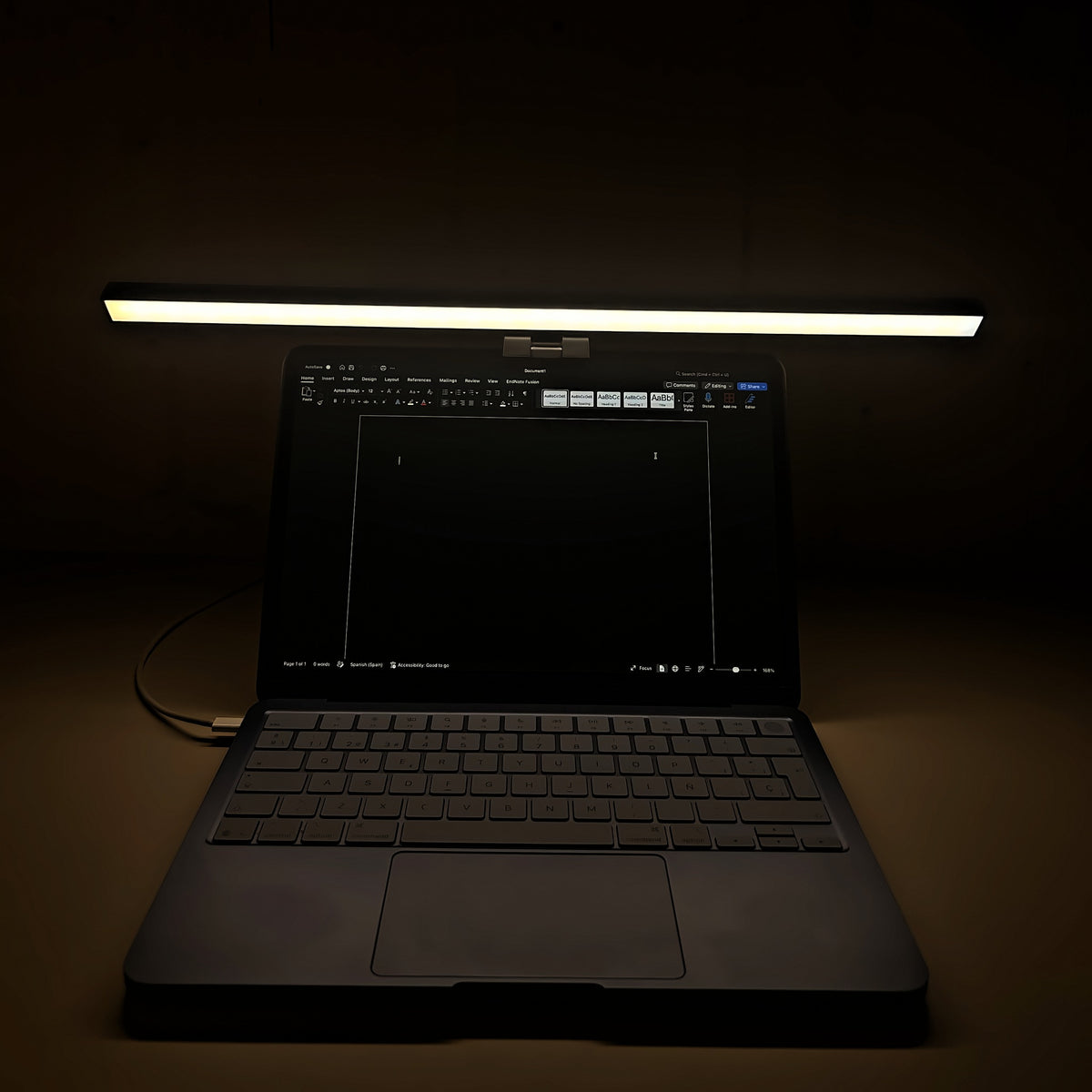 Lámpara Cenit de 50 cm con luz mixta encendida sobre un portátil en una habitación a oscuras